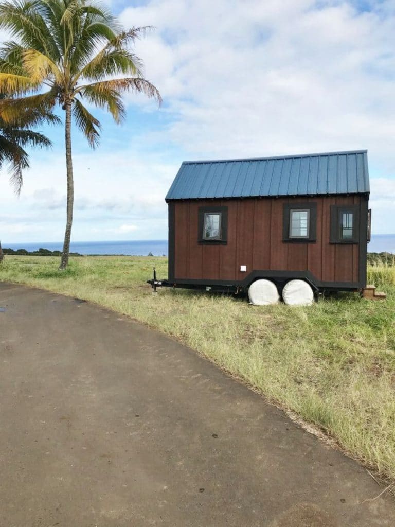 TIny house on wheels on grass by beach
