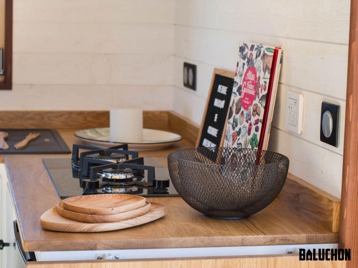 Wire bowl and wooden plates on counter next to gas stove