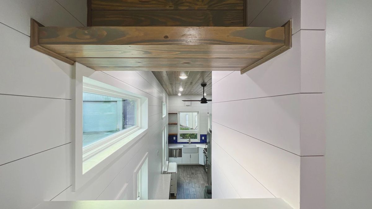 view across top of tiny home from loft showing tall walls and wood ceiling