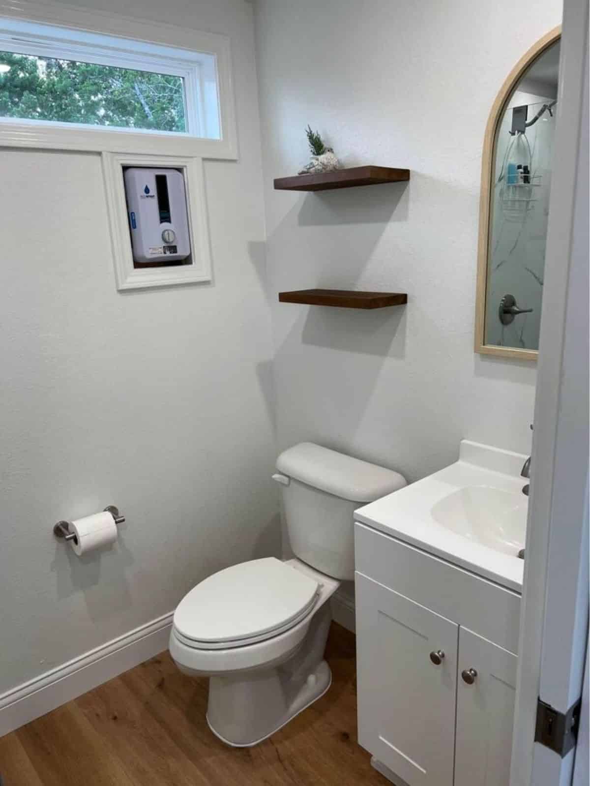 wooden shelves installed in the bathroom above the standard toilet