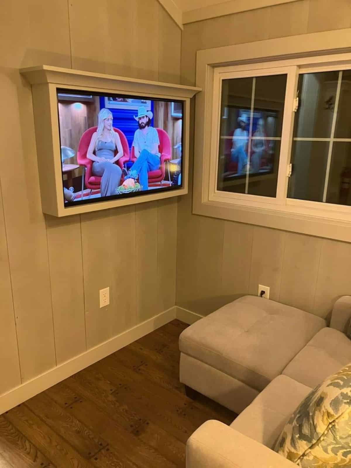 wall mounted TV set in front of the couch